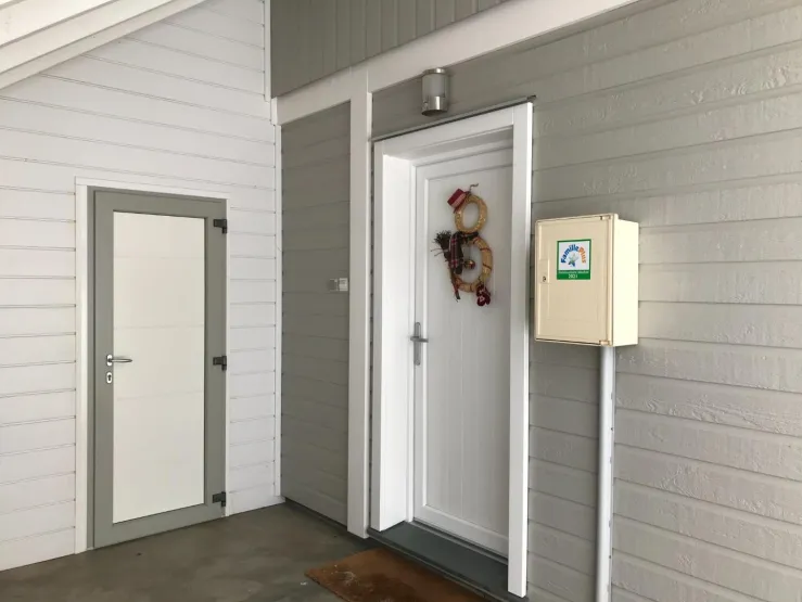 Entrance under a covered porch with access to the ski / bicycle room