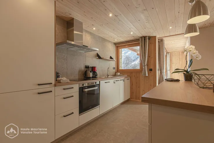 La cuisine toute équipée avec appareils ménagers intégrés et son îlot.