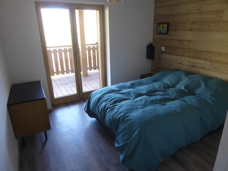 la Chambre 1 avec sa porte-fenêtre sur la terrasse et la vue sur les montagnes