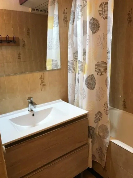 Salle de bain avec WC, meuble de salle de bain et baignoire.