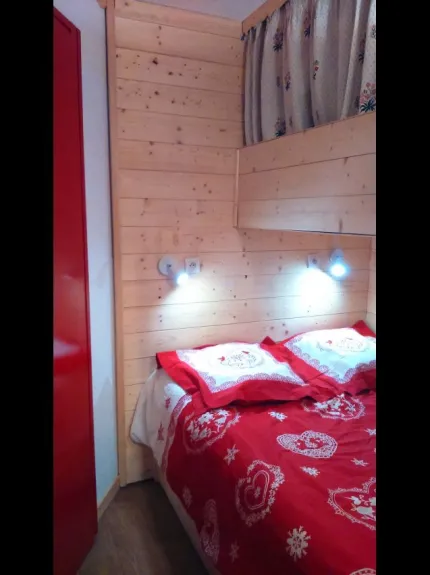 cabine fermée avec lit double et un lit simple superposée à l'entrée de l'appartement.