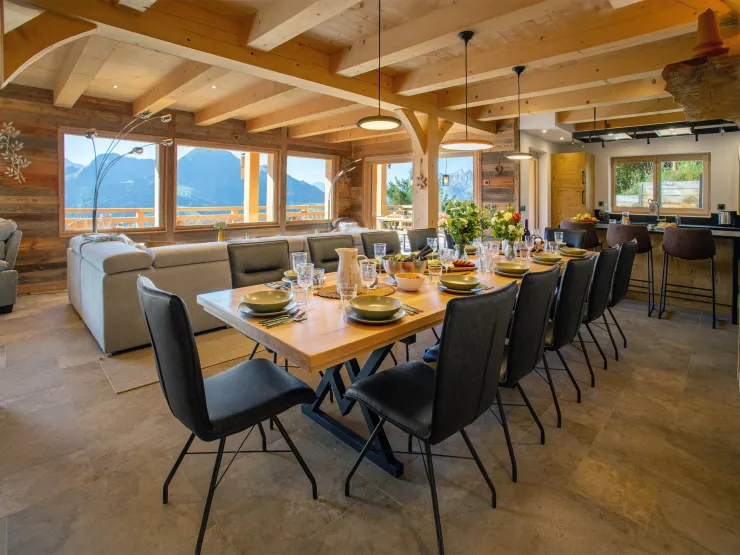 Large dining table with panoramic Alpine views. A bright, elegant space perfect for gathering with family or friends while enjoying an exceptional mountain setting.