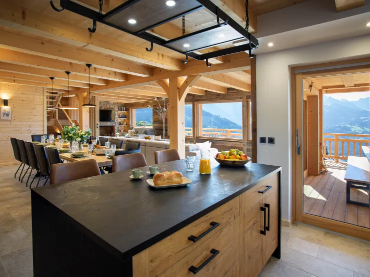 Spacious, fully equipped kitchen open to the living area and mountain views. A refined space combining comfort, natural light, and the joy of cooking facing the peaks.