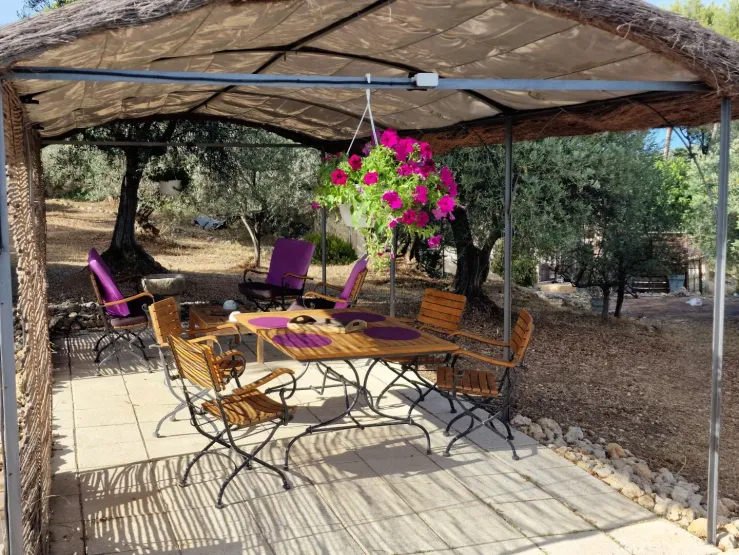 Tonnelle de l'oliveraie avec coin repas et salon détente face à  la piscine et à  la cuisine d'été
