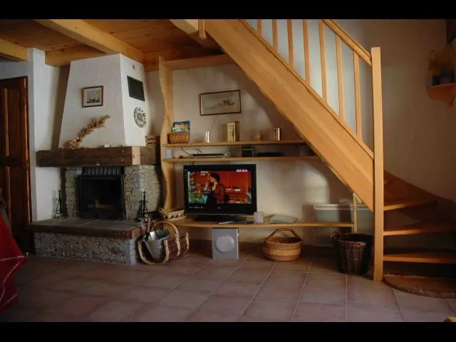 Aménagement  sous escalier montant en mezzanine, cheminée avec foyer fermé, étagère avec écran plat LCD, radio/lecteur multiple (Divx, DVD, etc)
