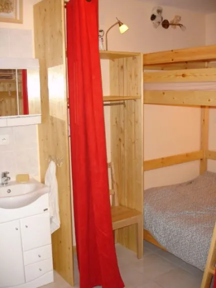La chambre coin montagne avec 2 lits doubles et un lave main.