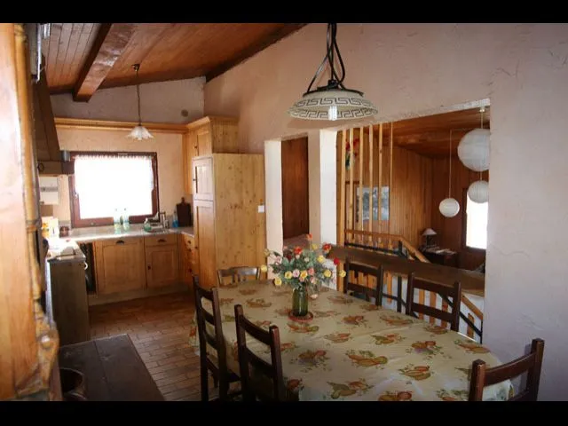 Salle à manger et cuisine ouverte. Plan de travail en granit rose, four électrique, lave vaisselle, plaques de cuisson vitro céramique, micro onde et frigo congélateur.