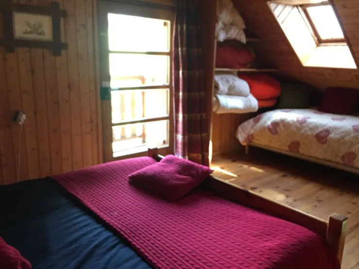La chambre 2 du second étage avec un lit double et petit balcon.