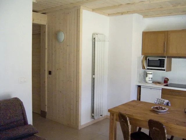 Pièce de vie avec le couloir qui donne accès à la chambre.
