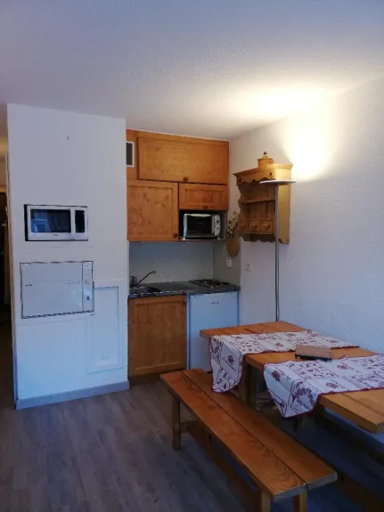 Coin cuisine - micro ondes- lave vaisselle - frigo - mini four - placards de rangement - étagère et  coin repas table et bancs