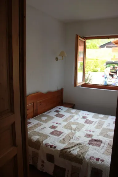 chambre avec un lit de 160, 1 placard de rangement et 2 tables de nuit. Elle donne sur le parking avec une fenêtre ouvrante