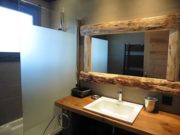 Salle de bain commune avec baignoire, sèche serviettes, et sèche cheveux