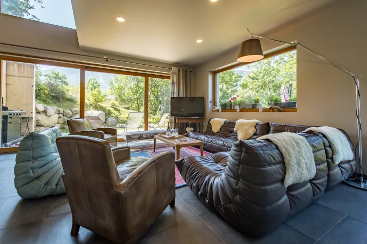 The living room with its large windows and direct access to the terrace and garden.