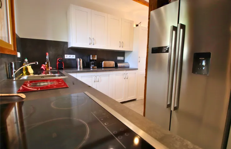 An ultra-modern open kitchen, equipped with high-performance hobs and a large American-style fridge to accommodate your families.
